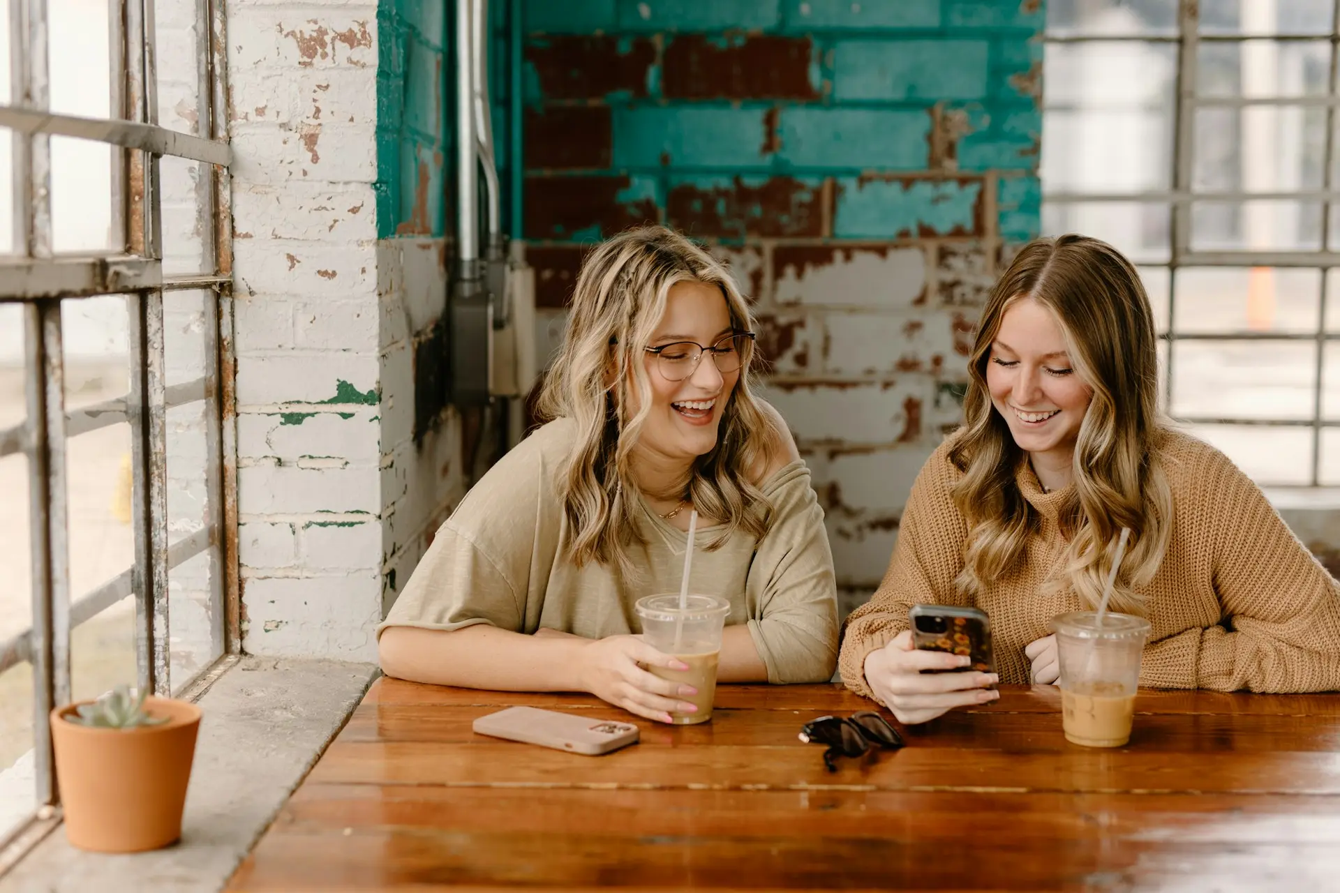 Two women at a table looking at a phone